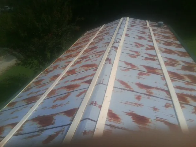 Rusted metal roof panels with new wood purlins before replacement — Storm Damage Roof Repair in Gardner by Roofing Brothers